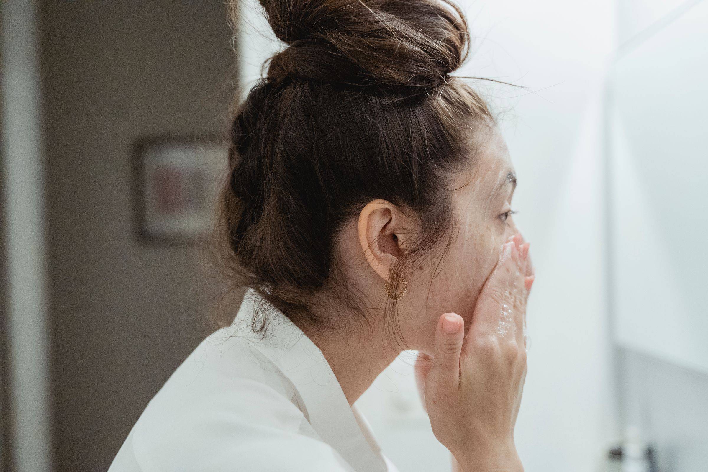 Soin du visage devant le miroir de la salle de bains